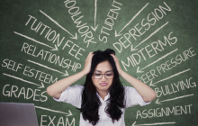 Student in front of chalk board and books looking very stressed