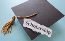 Graduation Cap with a paper that reads "scholarship" on it