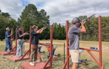 Participants of the clay shooting targets aiming at clay pigeon