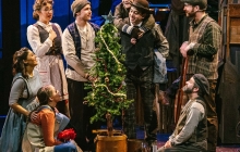 Theater performers around a Christmas Tree on Stage